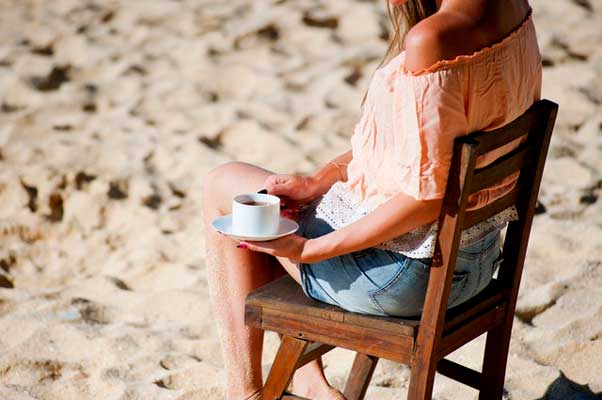 момиче-пие-кафе-на-плажа